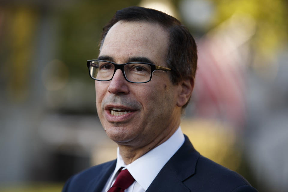 Treasury Secretary Steve Mnuchin talks with reporters outside the White House, Monday, Oct. 14, 2019, in Washington. (AP Photo/Evan Vucci)