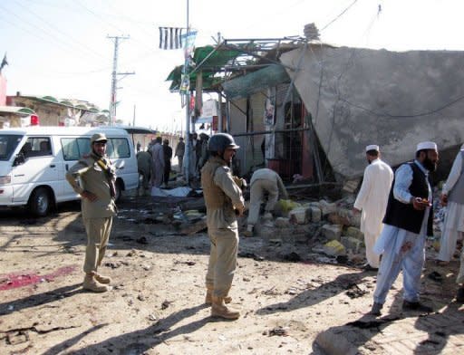 Pakistani security officials examine the site of a suicide bombing in Khar, the main town of Bajaur district, near the Afghan border. A teenage suicide bomber targeted police in a bustling Pakistan town square on Friday, killing at least 24 people and wounding dozens in the tribal area near the Afghan border, officials said