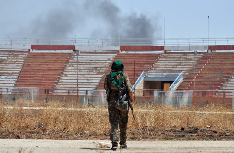 A member of the Kurdish People's Protection Units in a damaged stadium on July 26, 2015 in the Al-Nashwa neighbourhood of the Syrian province of Hasakeh during clashes with Islamic State group jihadists