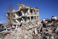 A man sits at his destroyed house in Kahramanmaras, southern Turkey, Wednesday, Feb. 8, 2023. With the hope of finding survivors fading, stretched rescue teams in Turkey and Syria searched Wednesday for signs of life in the rubble of thousands of buildings toppled by a catastrophic earthquake. (AP Photo/Hussein Malla)