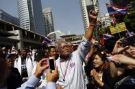 Protest leader Suthep Thaugsuban greets the crowd as he leads anti-government protesters marching through Bangkok's financial district January 21, 2014. Some Thai rice farmers have threatened to switch sides and join protesters trying to topple the government if they do not get paid for their crop, a worrying development for Prime Minister Yingluck Shinawatra whose support is based on the rural vote. REUTERS/Damir Sagolj (THAILAND - Tags: POLITICS AGRICULTURE BUSINESS CIVIL UNREST)