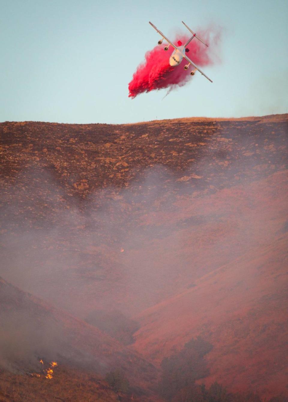 An air tanker makes the last drop of the day above the San Luis Obispo County Probation Department as the sun sets. Firefighters battled the quick-moving Lizzie Fire in the hills above San Luis High School on Oct. 30, 2023.