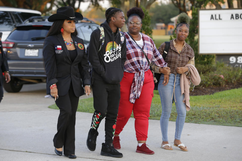 Candice Matthews, left, National minister of politics for the New Black Panther Nation; Darryl George, center left, a 17-year-old junior, and his mother Darresha George, center right, and a unidentified female, right, begin their walk across the street to go into Barbers Hill High School after Darryl served a 5-day in-school suspension for not cutting his hair Monday, Sept. 18, 2023, in Mont Belvieu. (AP Photo/Michael Wyke)