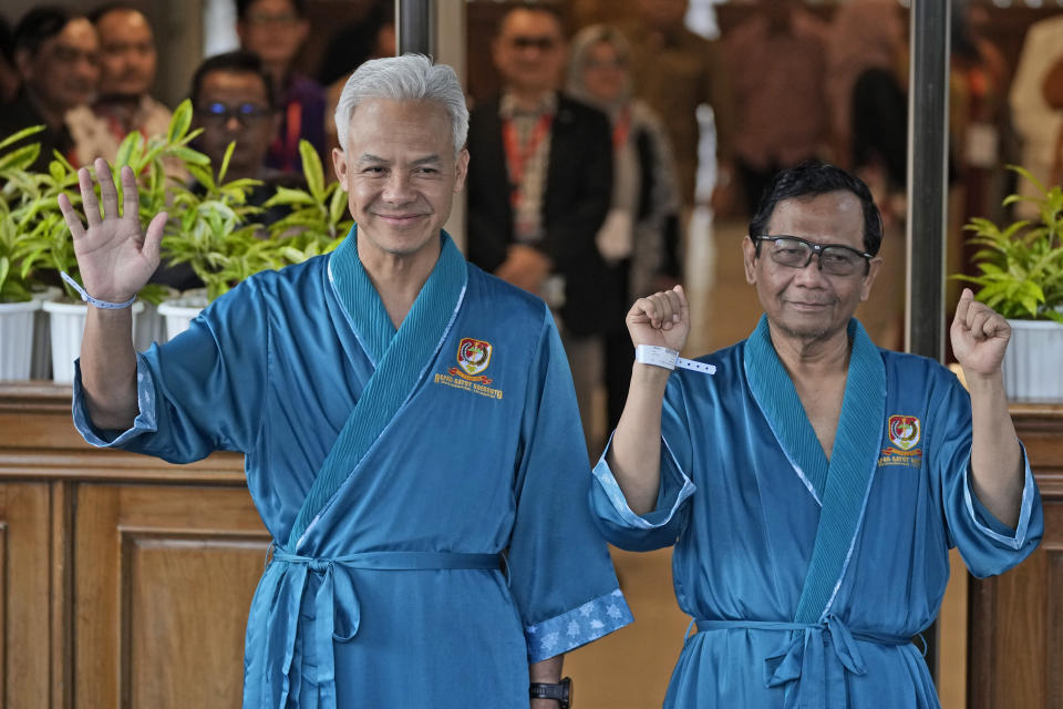 Presidential candidate Ganjar Pranowo, left, and his running mate Mohamad Mahfud, popularly known as Mahfud MD, greet reporters prior to their medical check up required for their candidacy in the upcoming presidential election, at Gatot Subroto Army Hospital in Jakarta, Indonesia, Sunday, Oct. 22, 2023. The world's third-largest democracy is holding its legislative and presidential elections on Feb. 14, 2024. (AP Photo/Dita Alangkara)