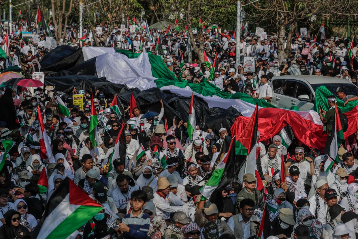 People hold a giant Palestinian flag during a rally in solidarity with the Palestinians, outside the US embassy in Jakarta, Indonesia (EPA)