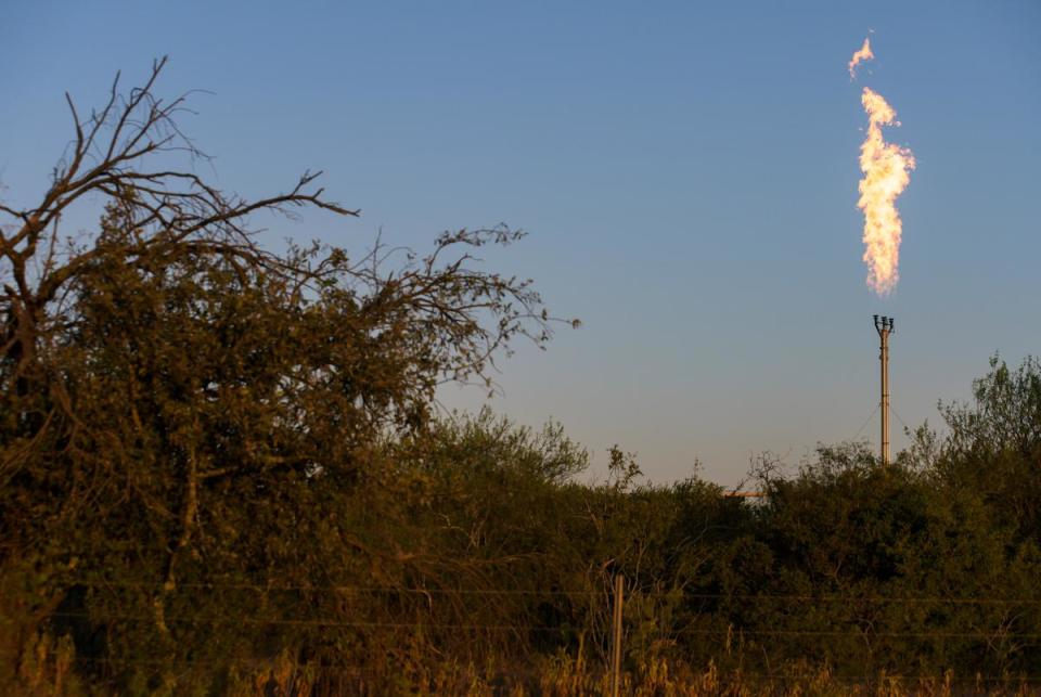 A flare buns off excess natural gas along Texas State Highway 80 Thursday, Aug. 17, 2023 in Karnes County.