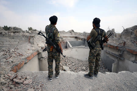 Fighters from Syrian Democratic Forces (SDF) stand near destroyed Uwais al-Qarni shrine in Raqqa, Syria September 16, 2017. REUTERS/Rodi Said