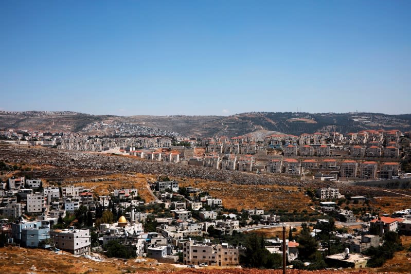 FILE PHOTO: A general view shows Palestinian houses in the village of Wadi Fukin as the Israeli settlement of Beitar Illit is seen in the background, in the occupied West Bank