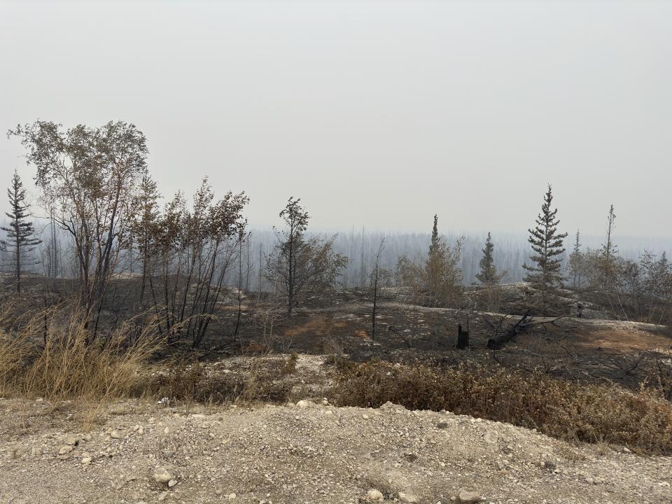 Damage from the wildfires is shown on Tuesday, Aug. 15, 2023 between Enterprise and Kakisa, Northwest Territories, Canada. Thousands of people in eight other communities, have already been forced to evacuate their homes, including the small community of Enterprise, where 80% of the town was destroyed. Officials said everyone made it out alive. (Ryan Planche via AP)