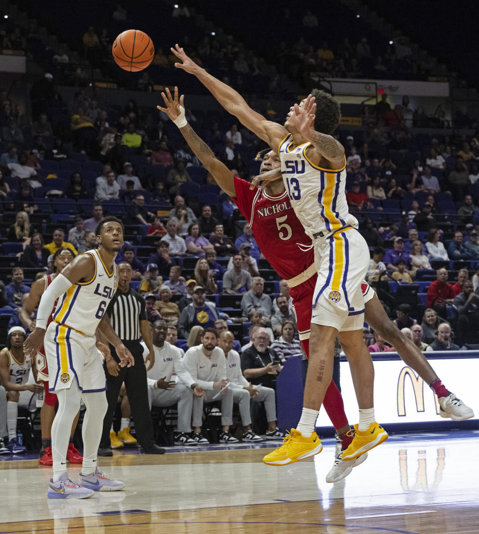 LSU guard Jordan Wright (6) watches as Nicholls forward Diante Smith (5) and LSU forward Jalen Reed (13) vie for a rebound during an NCAA college basketball game Friday, Nov. 10, 2023, in Baton Rouge, La. (Hilary Scheinuk/The Advocate via AP)