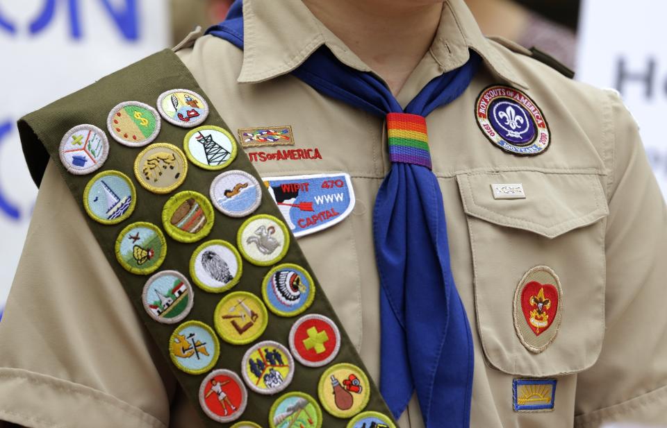 FILE - Merit badges and a rainbow-colored neckerchief slider are affixed on a Boy Scout uniform outside the headquarters of Amazon in Seattle. The U.S. organization, which now welcomes girls into the program and allows them to work toward the coveted Eagle Scout rank, announced Tuesday, May 7, 2024, that it will change its name to Scouting America as it focuses on inclusion. (AP Photo/Ted S. Warren, File)