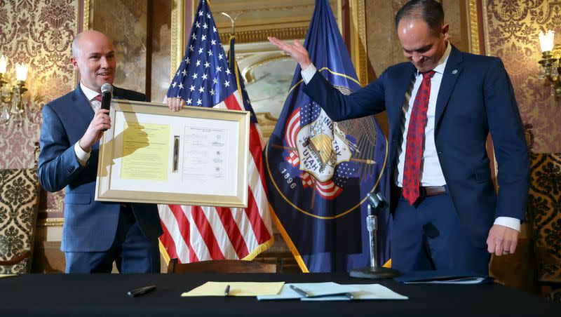 Sen. Mike McKell, R-Spanish Fork, right, gives Gov. Spencer Cox a framed copy of SB 228, Electronic Free Speech Amendments, which McKell sponsored and Cox vetoed in 2021, at the Capitol in Salt Lake City on Thursday, March 23, 2023.