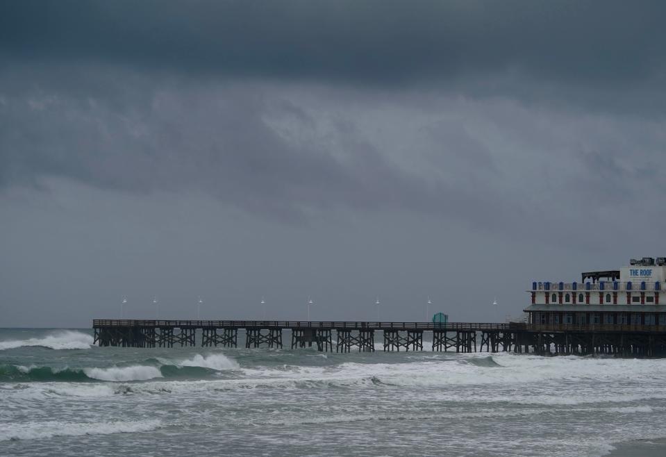 An ominous sky hangs over the Daytona Beach Boardwalk as waves churn on Wednesday. The impact of Hurricane Idalia were relatively minor in Volusia and Flagler counties, according to beachside residents and business owners.