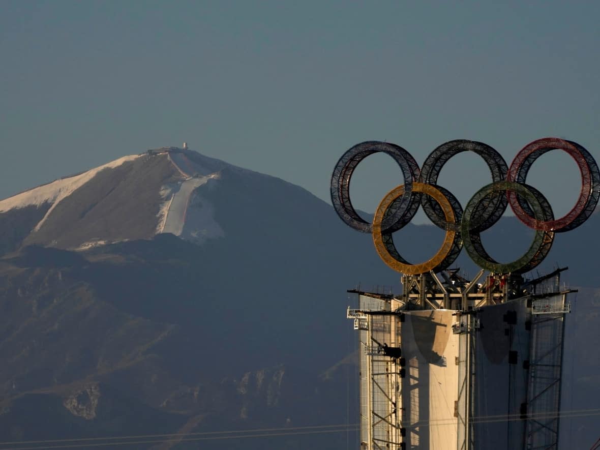 An Olympic rings display atop a structure stands near a ski resort in the outskirts of Beijing. CBC Sports has learned the Beijing Olympic Committee is using a higher threshold for detecting COVID-19, making it harder for Canadian athletes to pass testing.  (Ng Han Guan/The Associated Press - image credit)