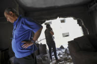 Miembros de la famila Sror revisan los daños a su apartamento, alcanzado por un cohete lanzado desde la Franja de Gaza, en Petah Tikva, en el centro de Israel, el jueves 13 de mayo de 2021. (AP Foto/Oded Balilty)
