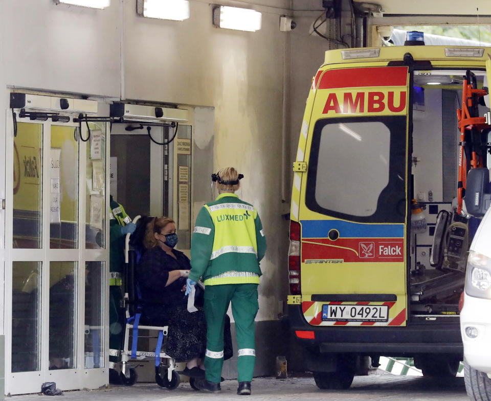 An ambulance brings a COVID-19 patient to a specialized hospital in Warsaw, Poland, Tuesday, Oct. 20, 2020. Poland is seeing a sharp spike in new cases daily of coronavirus infections, filling up hospital beds. Poland's government is transforming the National Stadium in Warsaw into a field hospital to handle the surging number of people infected with the coronavirus, and expects it to be operational within days, officials said. (AP Photo/Czarek Sokolowski)