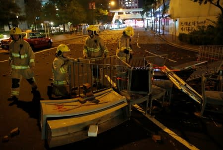 Fire fighters remove a barricade set up by anti-government protesters during a demonstration at Tam Kon Po Street in Hong Kong