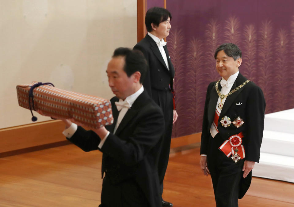 Japan's new Emperor Naruhito, right, leaves after the ceremony to receive the Imperial regalia of sword and jewel as proof of succession at Imperial Palace in Tokyo, Wednesday, May 1, 2019. Standing at back is Crown Prince Akishino. (Japan Pool via AP)