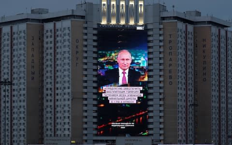 A screen shows a quote from Russian President Putin's address to the Federal Assembly in Moscow - Credit: REUTERS/Evgenia Novozhenina