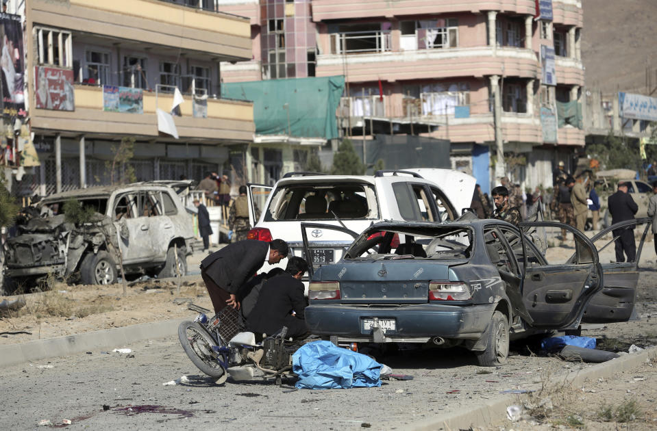 Security personnel gather at the site of car bomb attack in Kabul, Afghanistan, Wednesday, Nov. 13, 2019. A car bomb detonated in the Afghan capital during Wednesday's morning commute killing seven people and wounding at least seven, officials said. (AP Photo/Rahmat Gul)