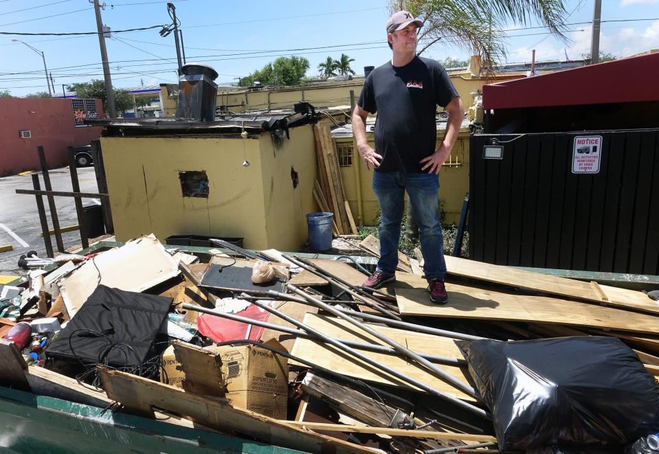 General Manager David Hazen stands on a dumpster of debris from the fire which heavily damaged H.G. Rooster's June 26, 2020 in West Palm Beach. A fire broke out just after 2:30 a.m on May 19. Rooster's owner, A.J. Wasson, said that he had lapsed on paying liability insurance for the building in order to keep paying his employees while the bar was closed due to state and local coronavirus restrictions. The fire was ruled accidental.