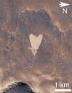 Esta imagen de un cráter con forma de corazón fue captada en la región llamada Arabia Terra, el 23 de mayo de 2010. Tiene cerca de un kilómetro de largo y al igual que otros fenómenos, se formó por causa del viento que hizo que partículas livianas de arena se dispersaran dejando un claro sobre la superficie.
