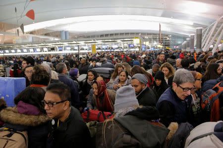 Large crowds try to make their way through the departures area of Terminal 4 at John F. Kennedy International Airport following a series of delayed and canceled flights and a water main break in New York City, U.S. January 7, 2018. REUTERS/Andrew Kelly