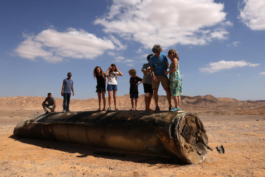 Varias personas se suben sobre los restos de un misil iraní en el desierto del Néguev, cerca de Arad, el 2 de octubre de 2024, tras un ataque con misiles iraníes contra Israel. Israel prometió hacer que Irán 