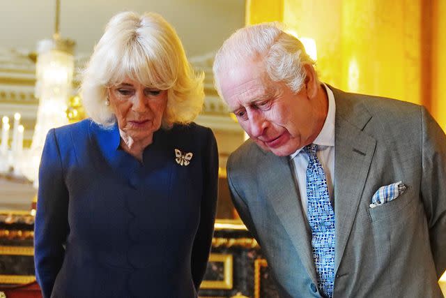 <p>Victoria Jones - WPA Pool/Getty</p> Queen Camilla and King Charles are presented with the coronation roll at Buckingham Palace on May 1, 2024