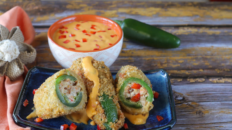 jalapeño poppers with queso on wood surface