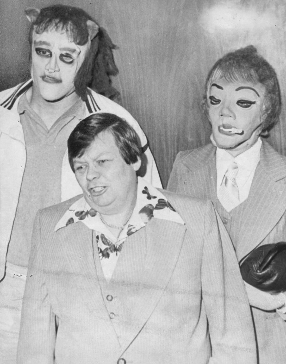 This 1979 photo shows transgender man Dante ‘Tex’ Gill, flanked by masked Frank Cocchiara, left, and Donna Potts while leaving the Public Safety Building in Pittsburgh, Pa. (Credit: Pittsburgh Post-Gazette via AP)