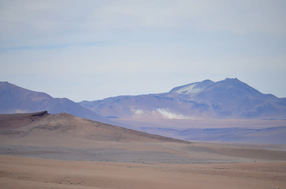 Chile's Atacama Desert is otherworldly, with red rocks and white salt coating the slopes of its mountains.