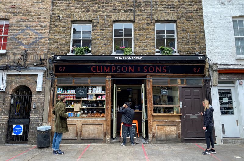 FILE PHOTO: People observe social distancing rules outside Climpson & Sons coffee shop in Hackney