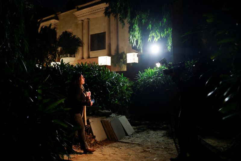 A reporter works outside the Israeli embassy, following a reported explosion nearby, in New Delhi
