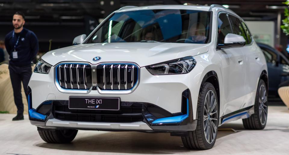 Man stands next to BMW iX1.