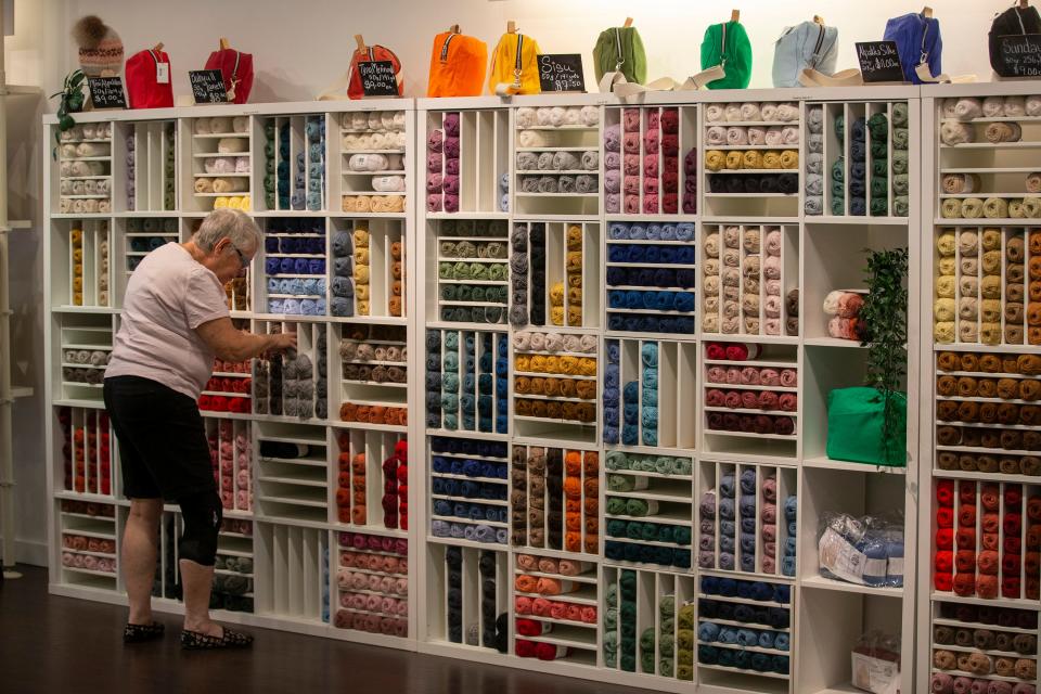 Leslie Tiras, retail sales associate, straightens shelves of yarn at Mother Knitter on Broad Street in Red Bank, NJ Friday, August 12, 2022.