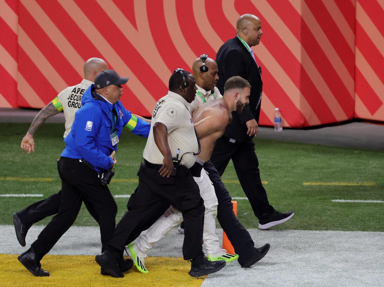 A fan is escorted away after running onto the field in the third quarter during Super Bowl 58 between the San Francisco 49ers and Kansas City Chiefs at Allegiant Stadium on February 11.