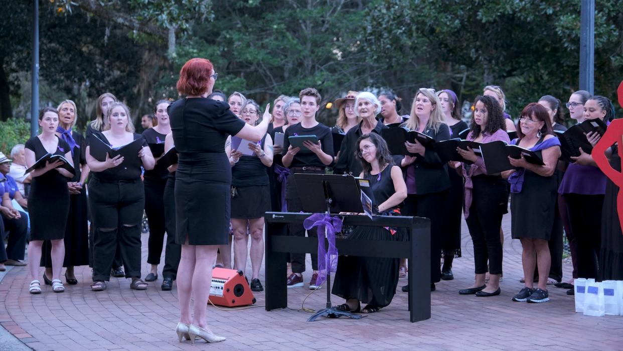 Tegan Miller directs Spectra Choir at the SAFE Shelter Candlelight Vigil at Forsyth Park on October 5th, 2023.