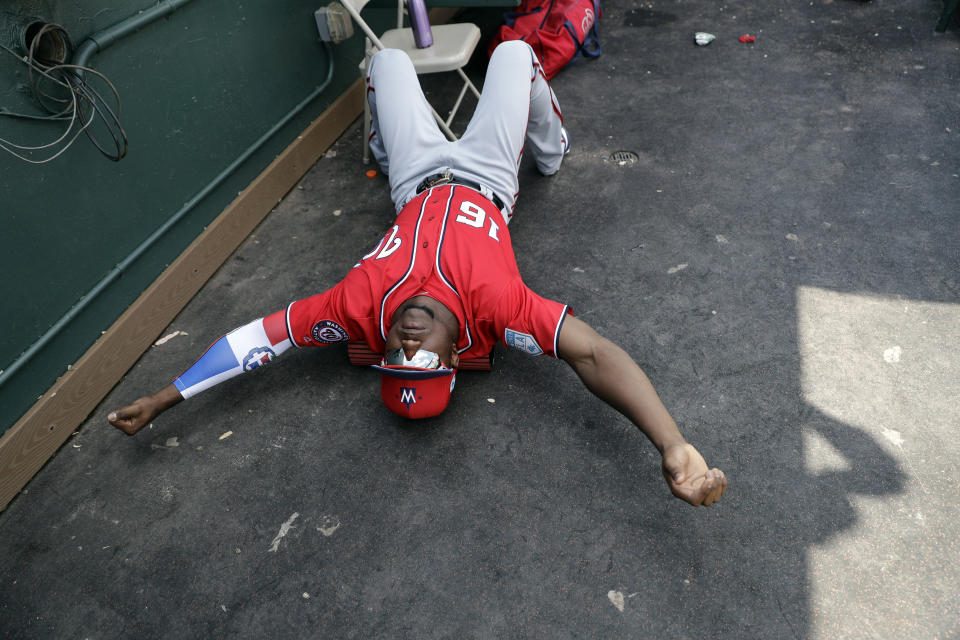 Washington Nationals' Victor Robles keeps loose by stretching in the dugout between innings of an exhibition spring training baseball game against the Miami Marlins Monday, March 4, 2019, in Jupiter, Fla. (AP Photo/Jeff Roberson)