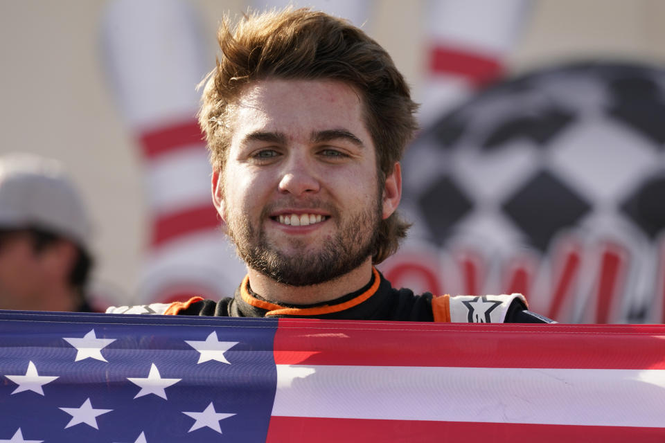 Noah Gragson (9) displays a U.S. flag as he celebrates winning the NASCAR Xfinity auto race in Richmond, Va., Saturday, Sept. 11, 2021. (AP Photo/Steve Helber)