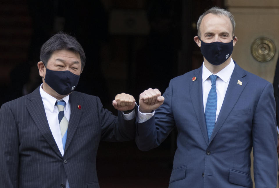 Japan's Foreign Minister Toshimitsu Motegi, left, poses with Britain's Foreign Secretary Dominic Raab at the start of the G7 foreign ministers meeting in London Tuesday May 4, 2021. G7 foreign ministers meet in London Tuesday for their first face-to-face talks in more than two years. (Steve Reigate / Pool via AP)