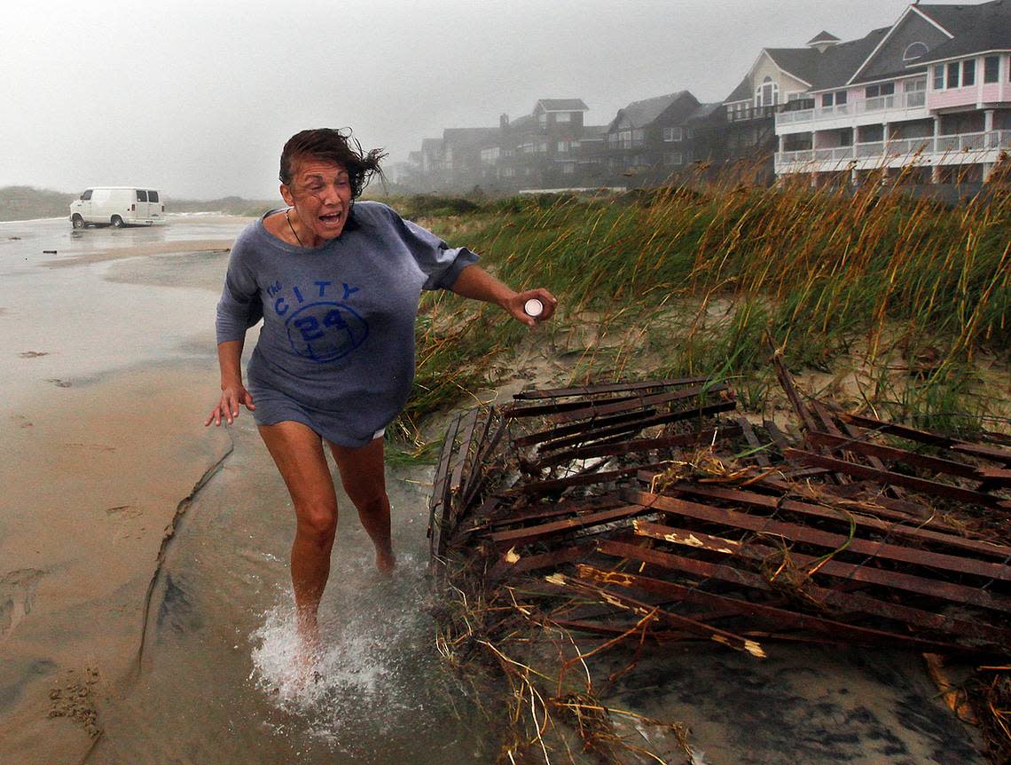 A woman abandons her van and her belongings near the Frisco Pier after overwash stranded her vehicle as the wind and rain of Hurricane Irene batters the Outer Banks.