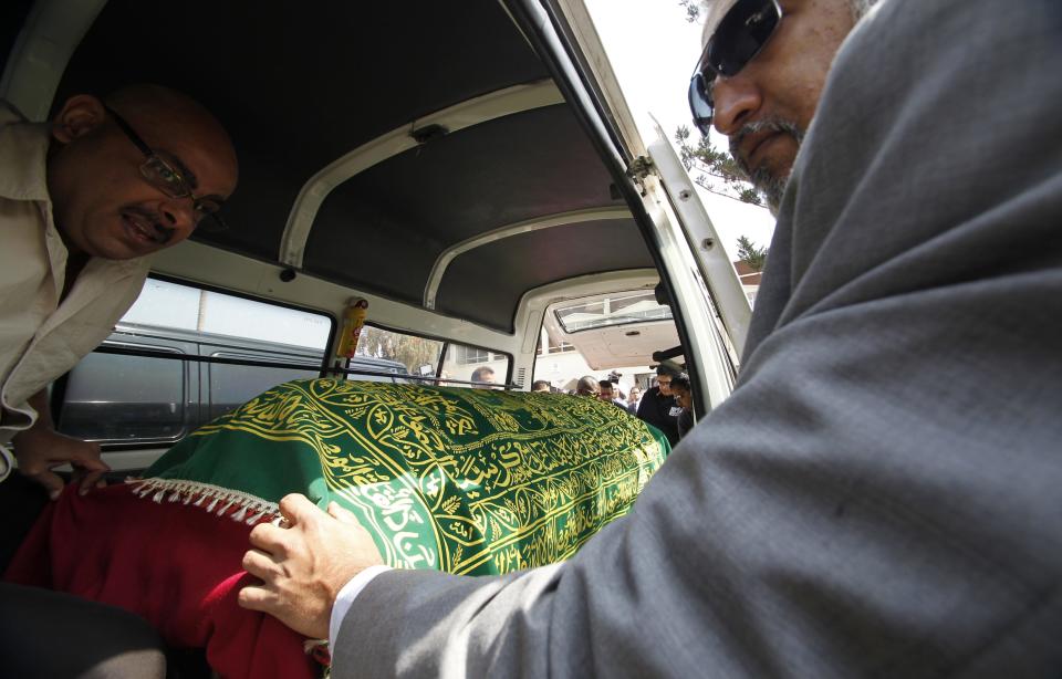 Relatives load the coffin with the remains of Kenyan civilian Dossa, who was killed in the Westgate shopping mall attack, during her funeral in Nairobi