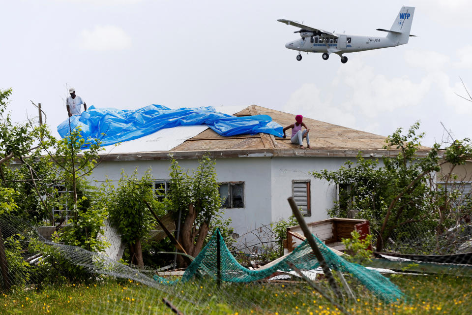 Devon Warner and his daughter Che Niesha work on the roof of a home at Codrington on the island of Barbuda just after a month after Hurricane Irma struck the Caribbean islands of Antigua and Barbuda