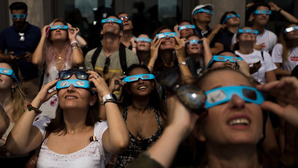 People view the solar eclipse at 'Top of the Rock' observatory at Rockefeller Center, August 21, 2017 in New York City. - Drew Angerer/Getty Images