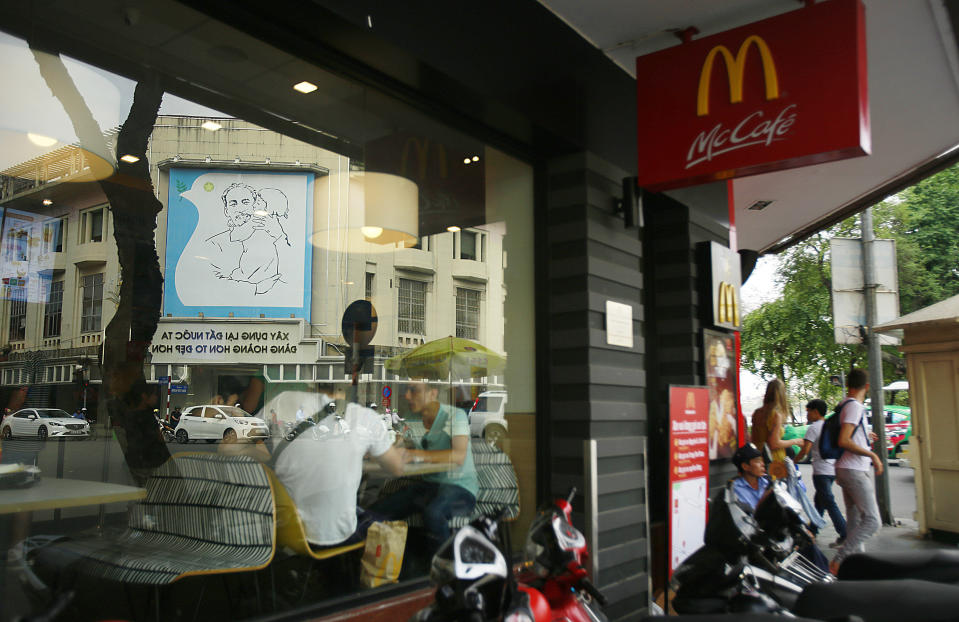 In this Feb. 21, 2019, photo, a poster of revolutionary leader Ho Chi Minh reflects on the glass window of a McDonald restaurant in Hanoi, Vietnam. The Vietnamese capital once trembled as waves of American bombers unleashed their payloads, but when Kim Jong Un arrives here for his summit with President Donald Trump he won’t find rancor toward a former enemy. Instead, the North Korean leader will get a glimpse at the potential rewards of reconciliation. (AP Photo/Hau Dinh)
