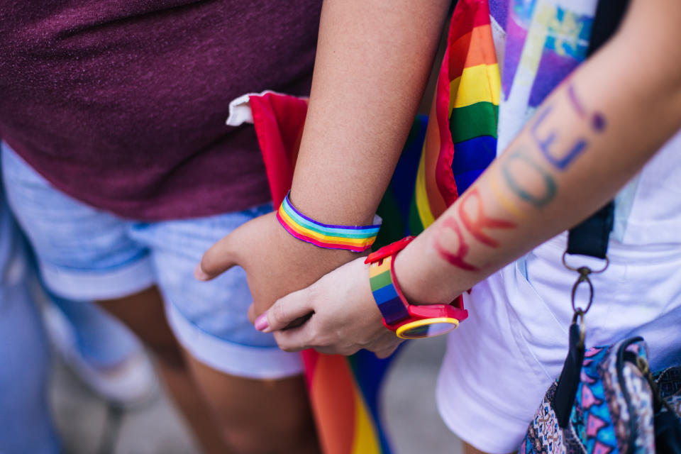 Two people holding hands at Pride celebrations. [Photo: Getty]