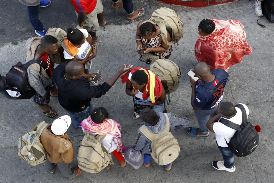 People gather as they wait to apply for asylum in the United States along the border, Tuesday, July 16, 2019, in Tijuana, Mexico. Dozens of immigrants lined up Tuesday at a major Mexico border crossing, waiting to learn how the Trump administration's plans to end most asylum protections would affect their hopes of taking refuge in the United States. (AP Photo/Gregory Bull)