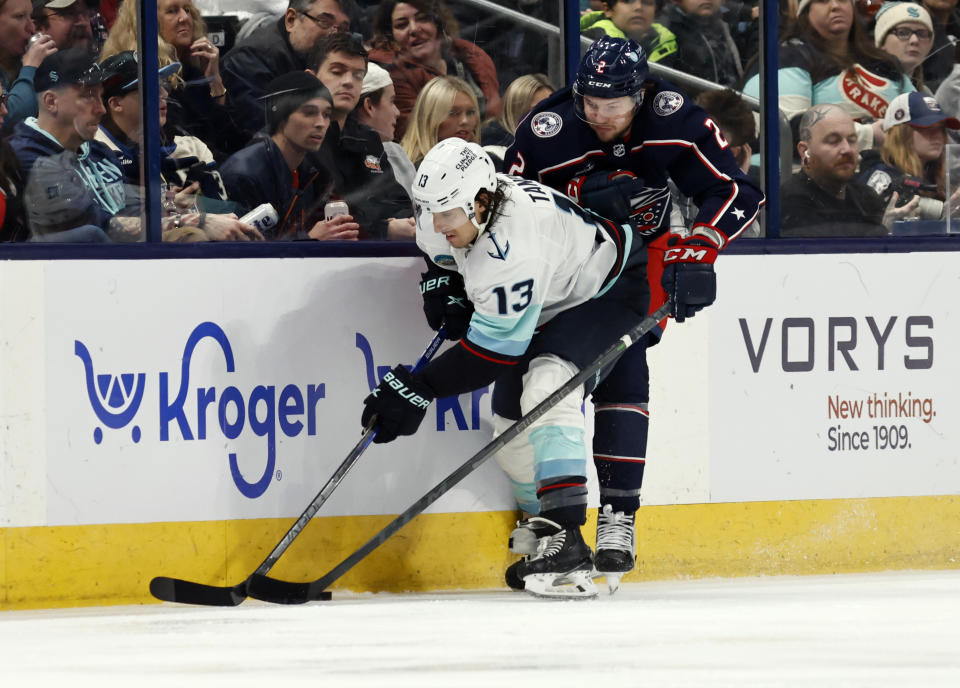 Seattle Kraken forward Brandon Tanev, left, works for the puck in front of Columbus Blue Jackets defenseman Andrew Peeke during the second period NHL hockey game in Columbus, Ohio, Saturday, Jan. 13, 2024. (AP Photo/Paul Vernon)