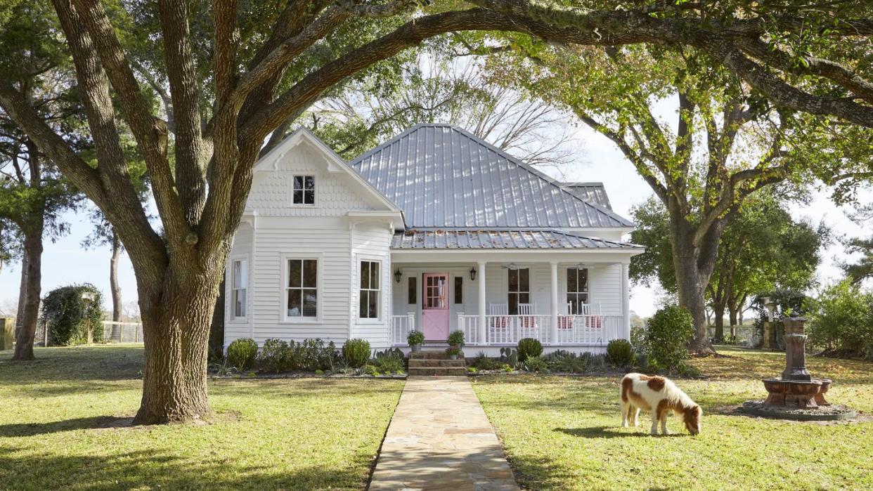 white farmhouse with pink front door